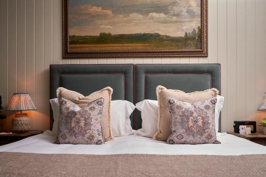 Burford on the Hill - Wonderful Winchcombe A painting of English countryside hangs above a large bed with decorative cushions